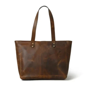 A brown leather tote bag, showcasing its sturdy and flat base, against a white background