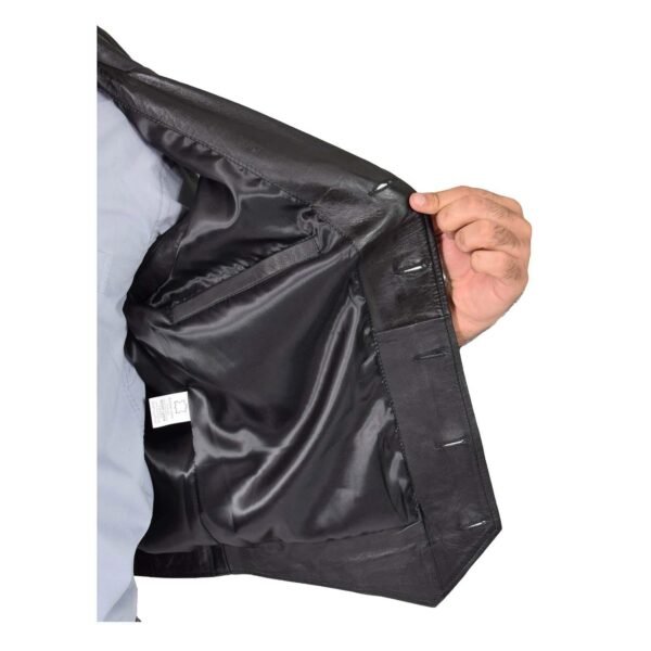 Close-up view of a hand holding open a Calvin black leather vest, showcasing the smooth inner lining and buttonhole details