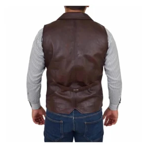 Back view of a man wearing a Calvin brown leather vest over a light gray button-up shirt, paired with blue jeans and a brown leather belt